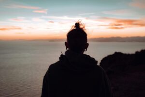 a silhouette of a person looking over the sea, depicting a self-discovery journey