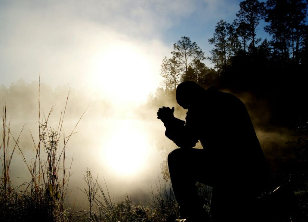 Man Praying On A Field